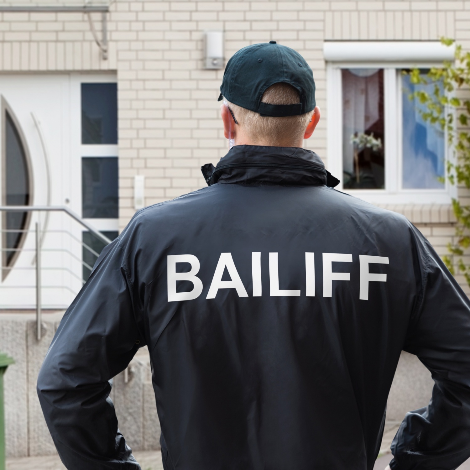 Rear,View,Of,A,Male,Bailiff,Standing,With,His,Hands